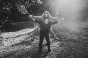 Husband giving Wife a ride on his back in a field.