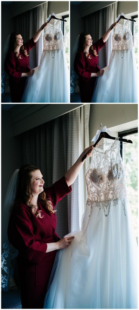 Bride smiling at her dress as she takes it off the hanger to put on for her ceremony.