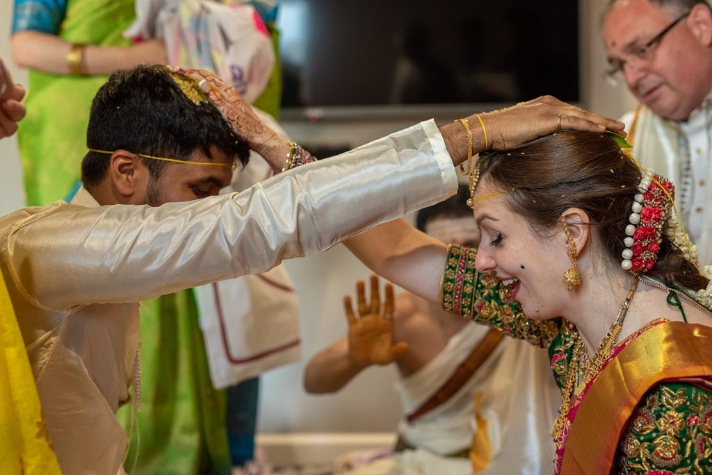 Bride and Groom exchange a mixture for applying to the tops of each others' heads in this traditional telagu wedding.