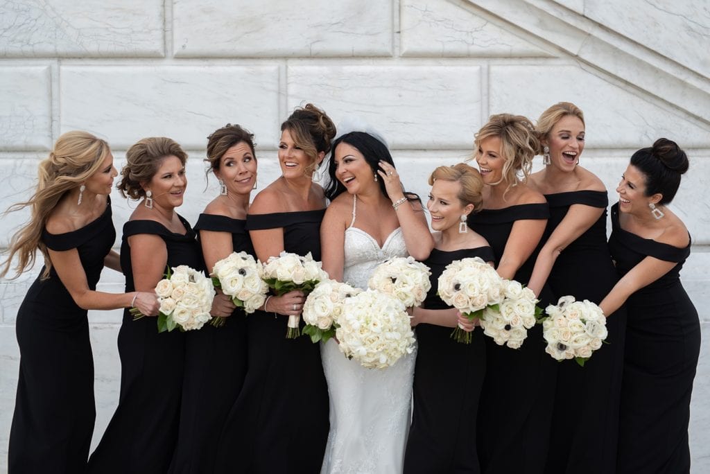 Bride and her Bridesmaids standing together and laughing during photos.