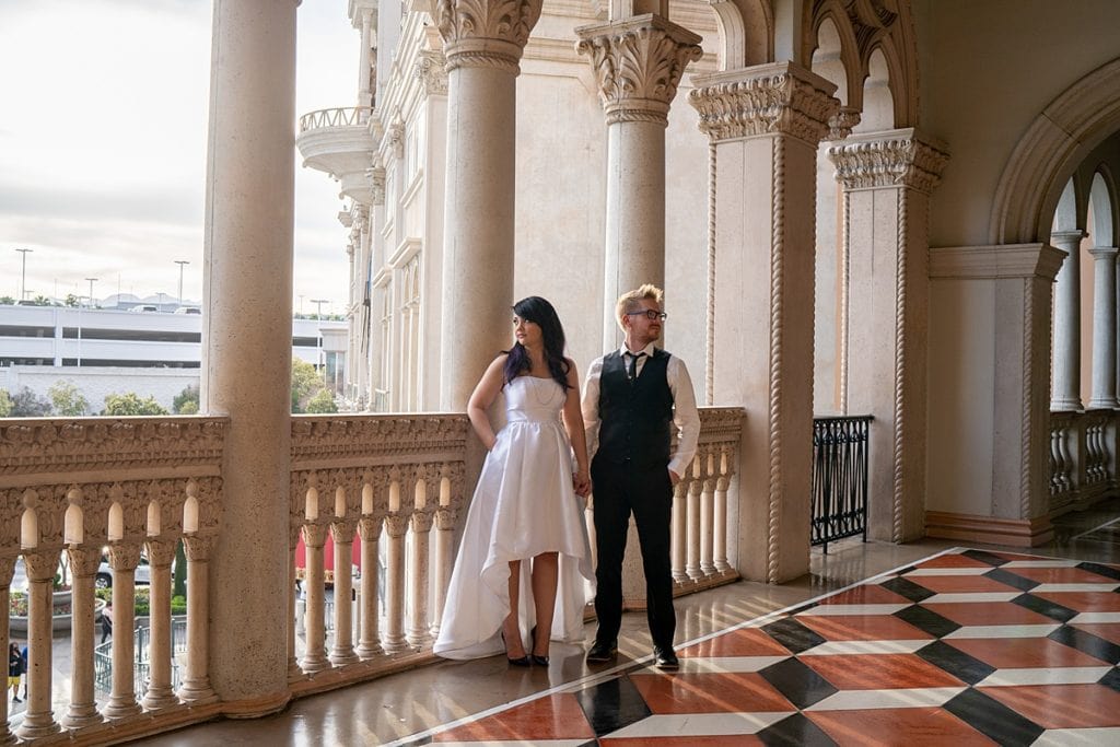 Bride and Groom pose looking away from each other on porch of the Venetian Resort in Las Vegas.