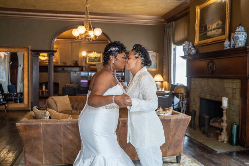 Brides kissing during their first look in downtown Detroit hotel.