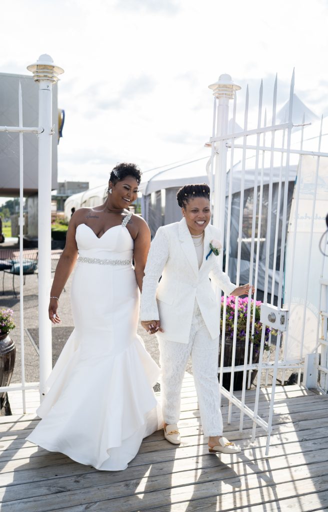 Brides walking through a gate together at the Roostertail in Detroit.