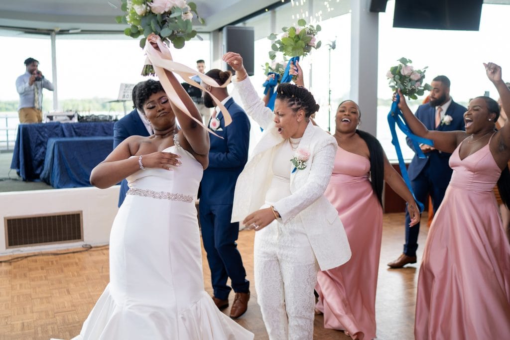 Brides dancing during their grand entrance at the Roostertail Detroit, reception.