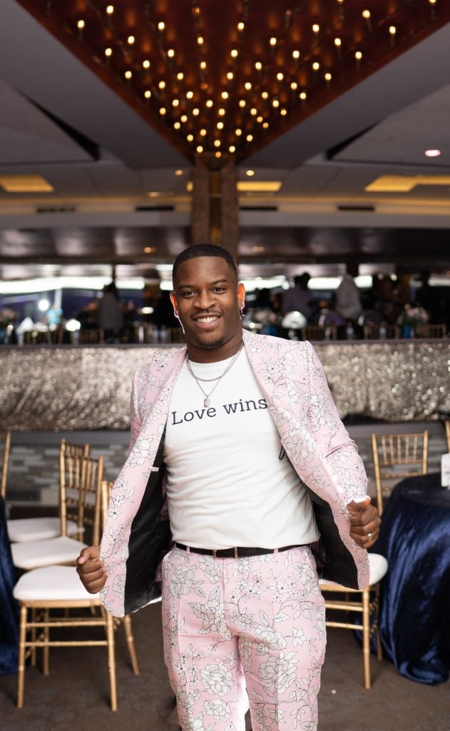 Man in a pink suit posing for a photo during a reception at the Roostertail in Detroit.