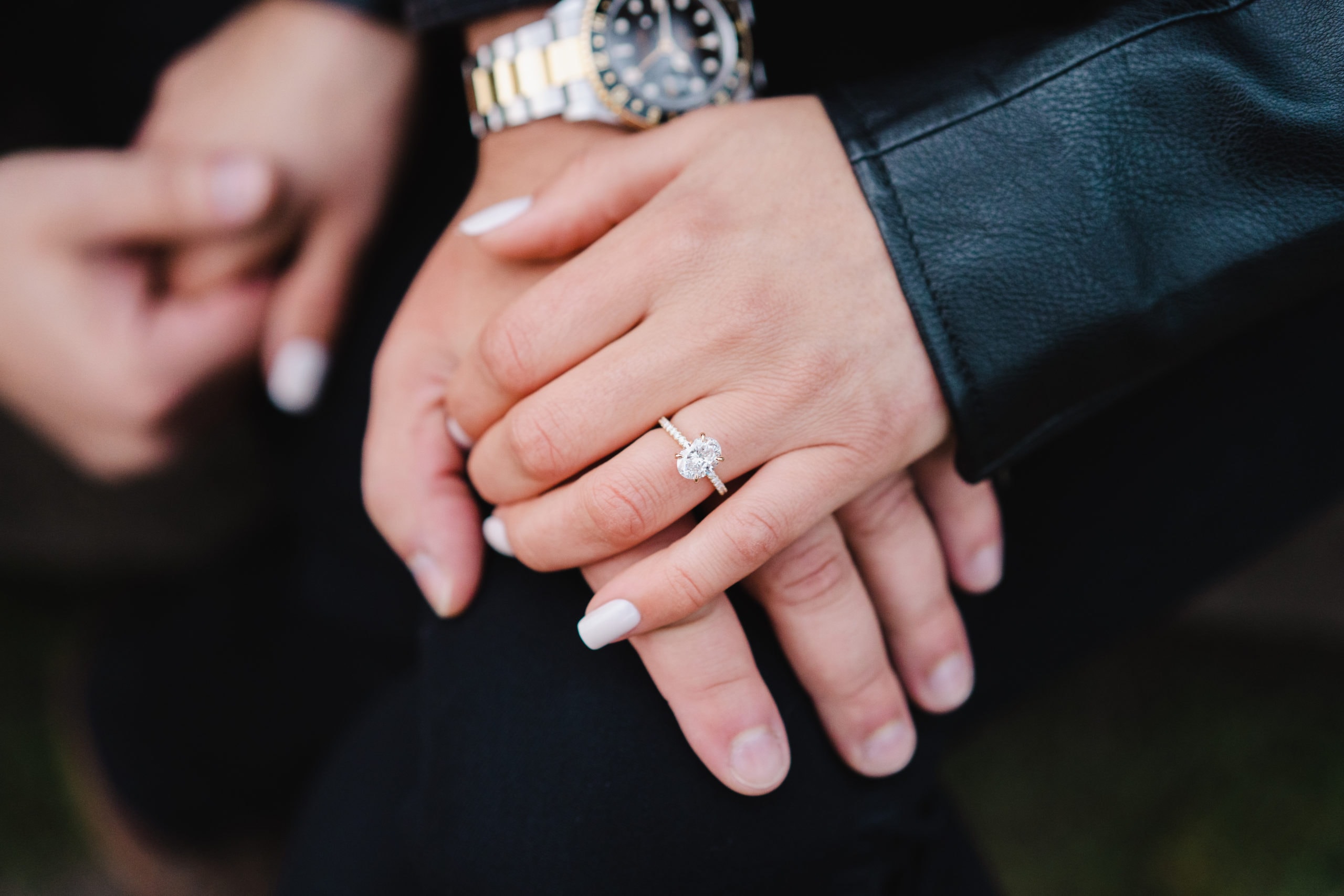 Couples hands posing for photo of new engagement ring.