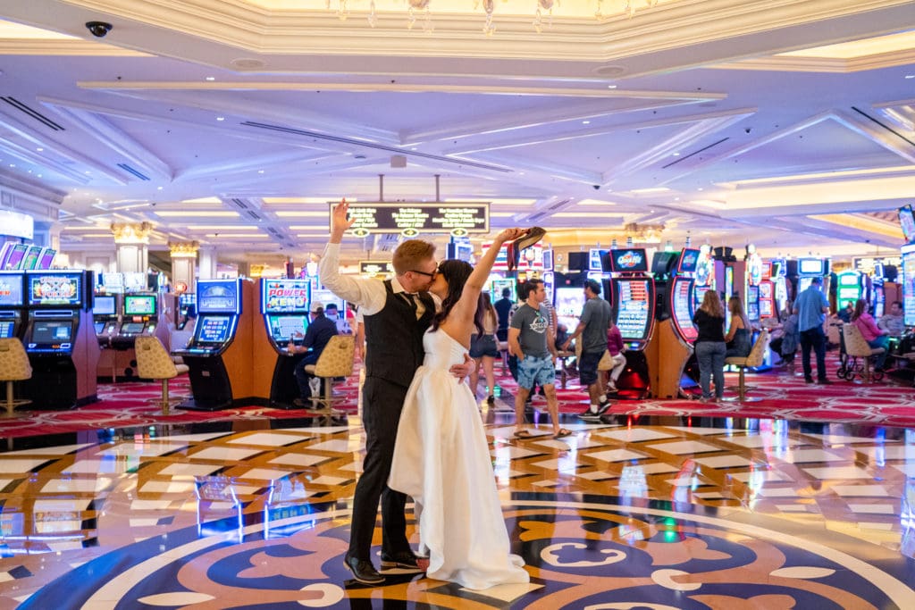 Bride and Groom kissing on Casino floor at the Bellagio in Vegas.