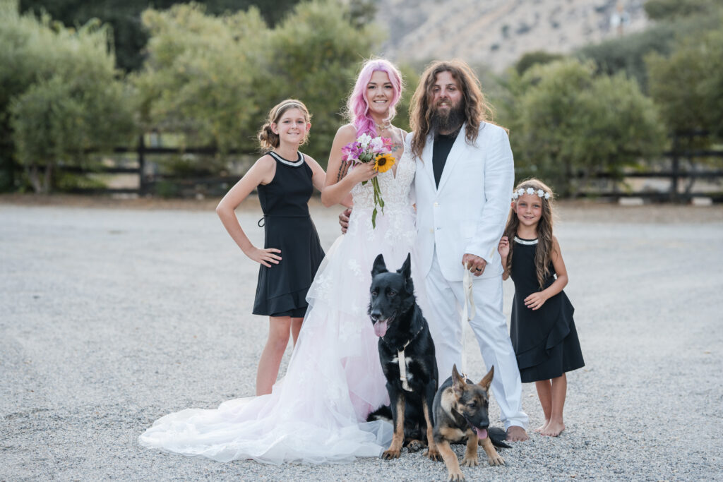 Family poses with their kids and dogs at their california winery wedding ceremony