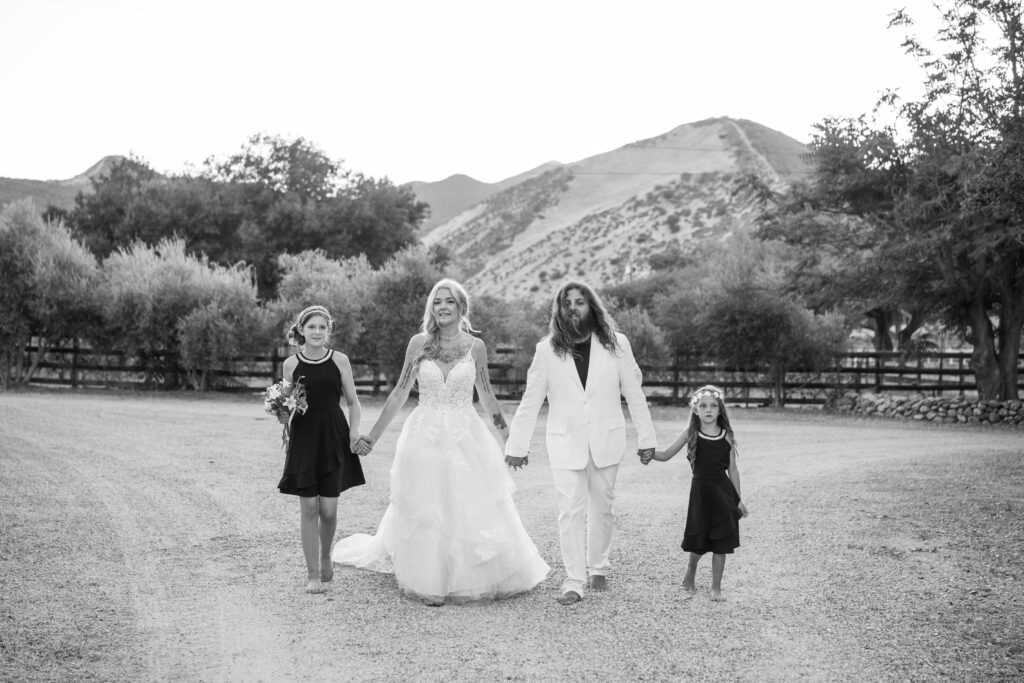 Whole family walking holding hands at their wedding in California